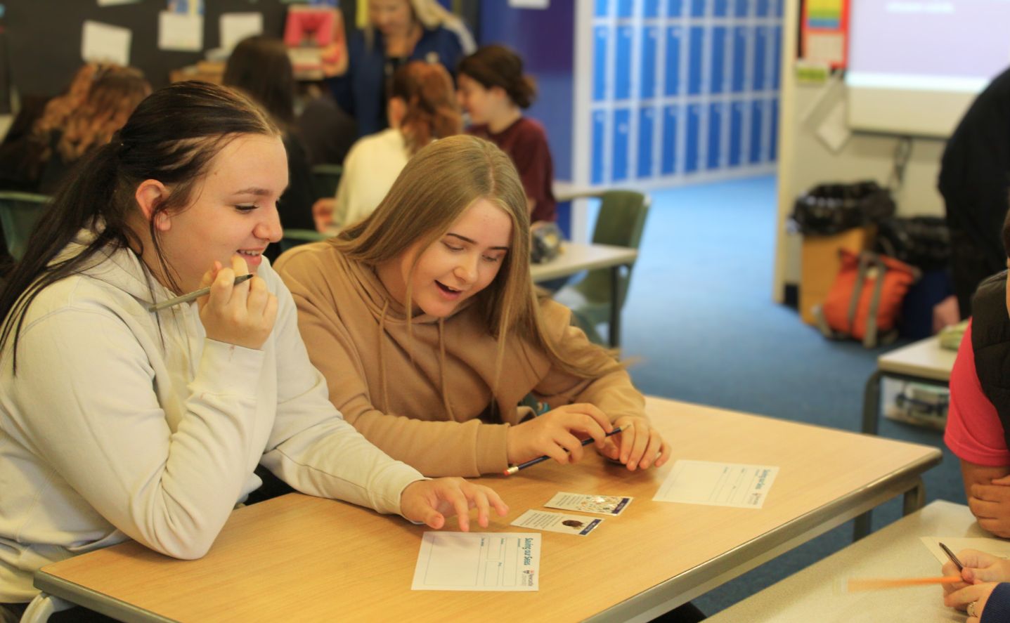 Two students sitting at a desk writing
